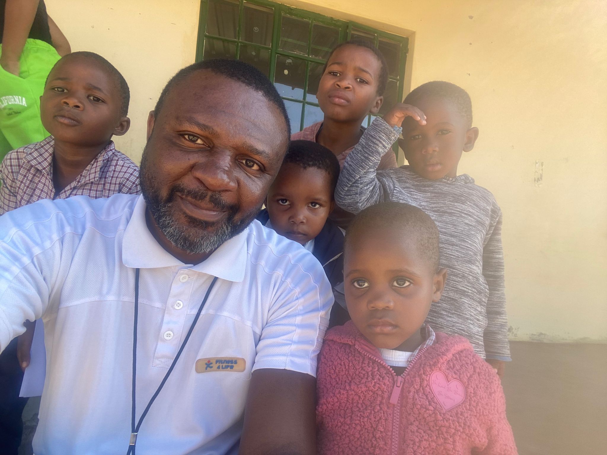 Dr. Williams Peprah in Eswatini posing with orphans for the Healing Crumbs Project